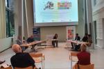 Podium mit 5 Personen vor einer Leinwand