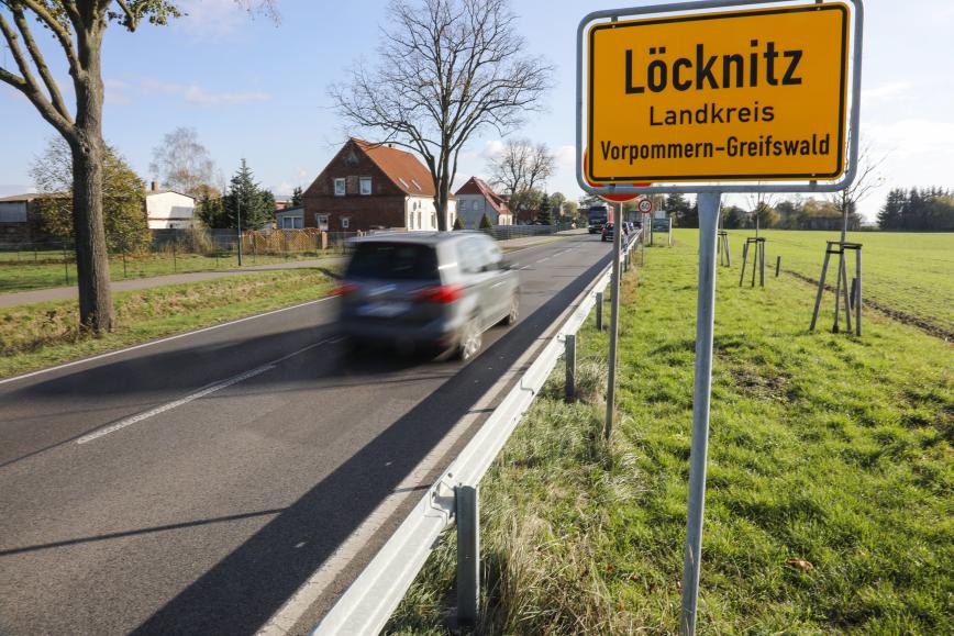 Ein Auto fährt am Orteingangsschild Löcknitz vorbei.