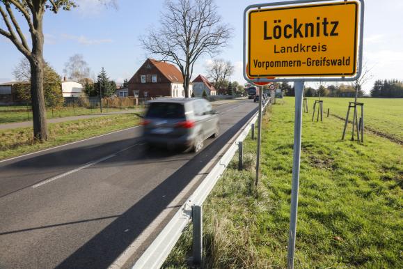 Ein Auto fährt am Orteingangsschild Löcknitz vorbei.